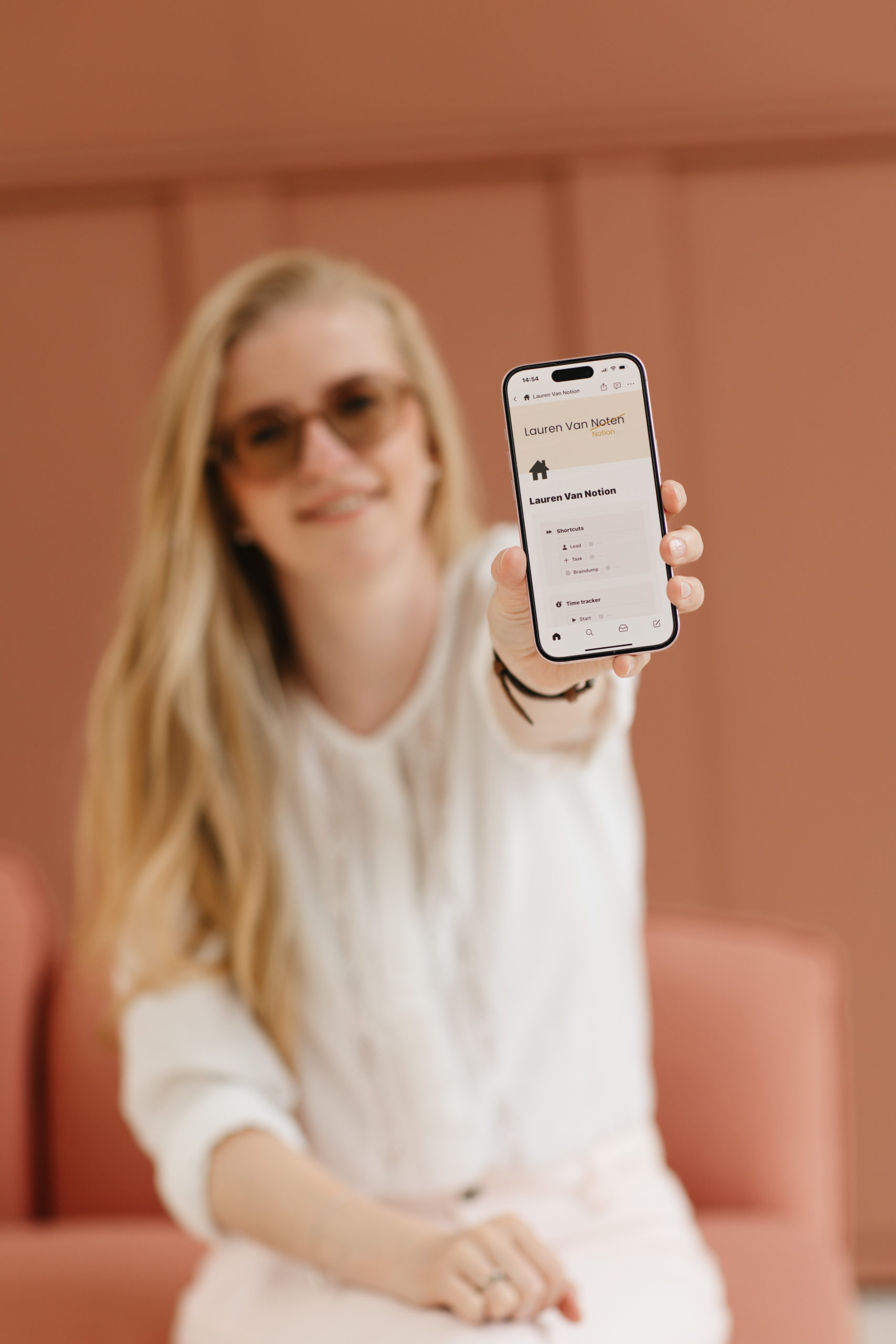 Lauren Van Noten houdt een smartphone met haar Notion-startpagina naar de camera.
